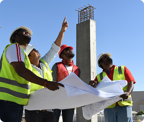 Construction workers reviewing blueprints on site