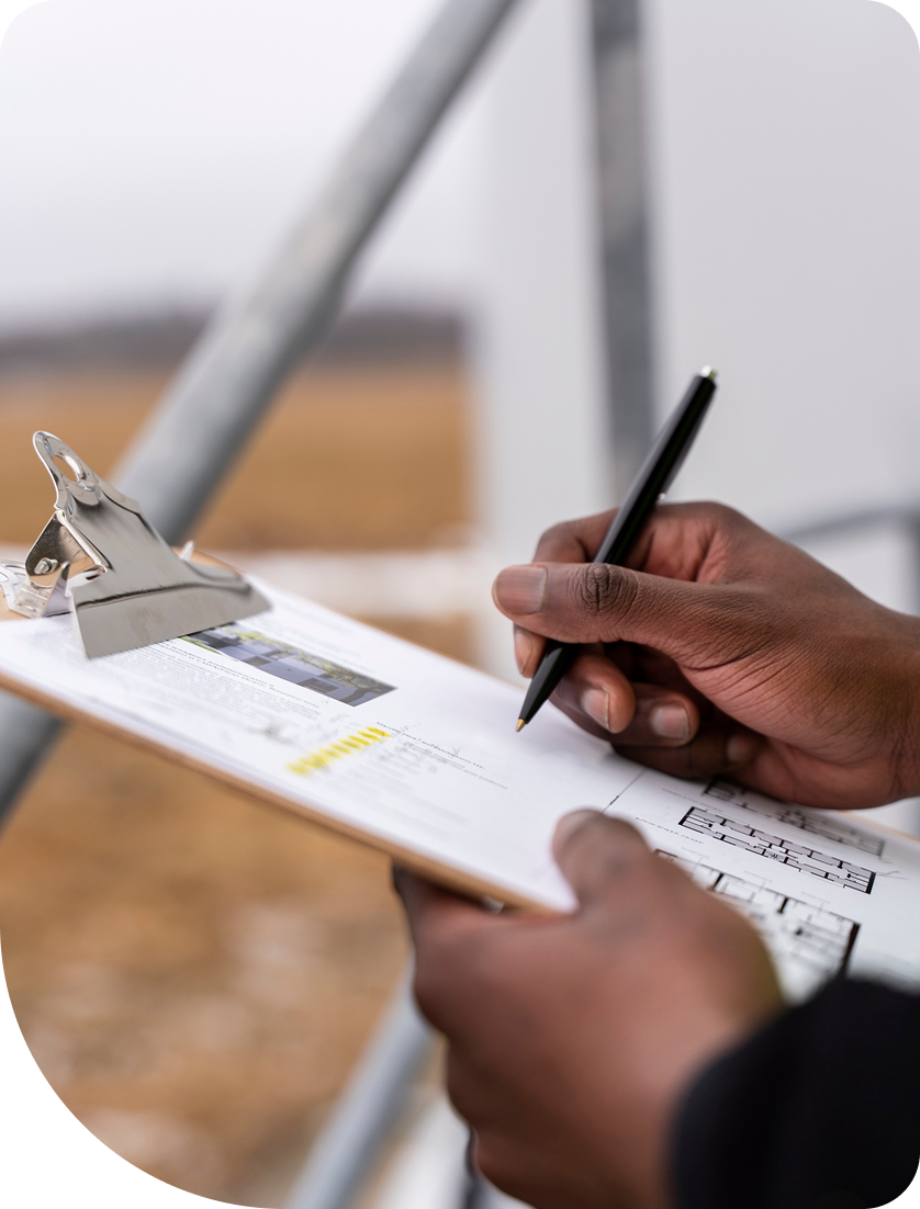 Person signing construction documents on clipboard